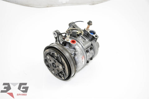 OEM factory AC compressor unit for Nissan Skyline R33 with RB20E engine, showing the front view with piping and connectors.