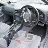 Nissan HR34 Skyline GT dashboard and interior overview — RHD with deployed airbag cover and 4AT shifter